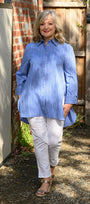 Front view  a blue striped shirt and white pants.