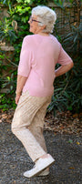Woman in a pink sweater and beige pants 