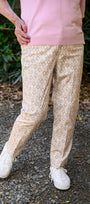 Front view pink top and beige patterned pants.