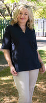 Front view a navy top and beige pants .