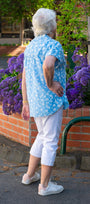 Woman in a blue shirt and white pants bsck view.