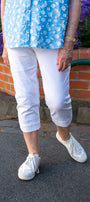 Person wearing a blue floral top, white pants, and white sneakers .