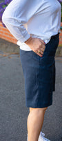 Side view  a white shirt and navy shorts.