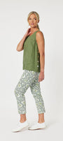 A female model wearing a green linen camisole with real shell buttons and matching green pants, standing against a plain background.