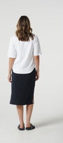 Person wearing a white shirt and navy skirt on a white background