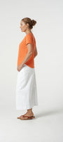 orange cotton tee shirt and white pants.