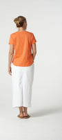 Back view orange cotton tee shirt and white pants.