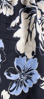A close-up of a floral fabric print featuring large light blue and off-white flowers with black outlines on a dark navy background.