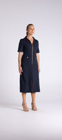 A woman modeling a dark navy blue midi dress with short sleeves, a collar, and a front zipper, standing against a light gray studio background.