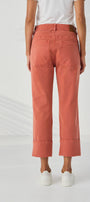  back view cropped wide leg jeans in a muted coral or terracotta pink color, paired with a white top and white sneakers, 