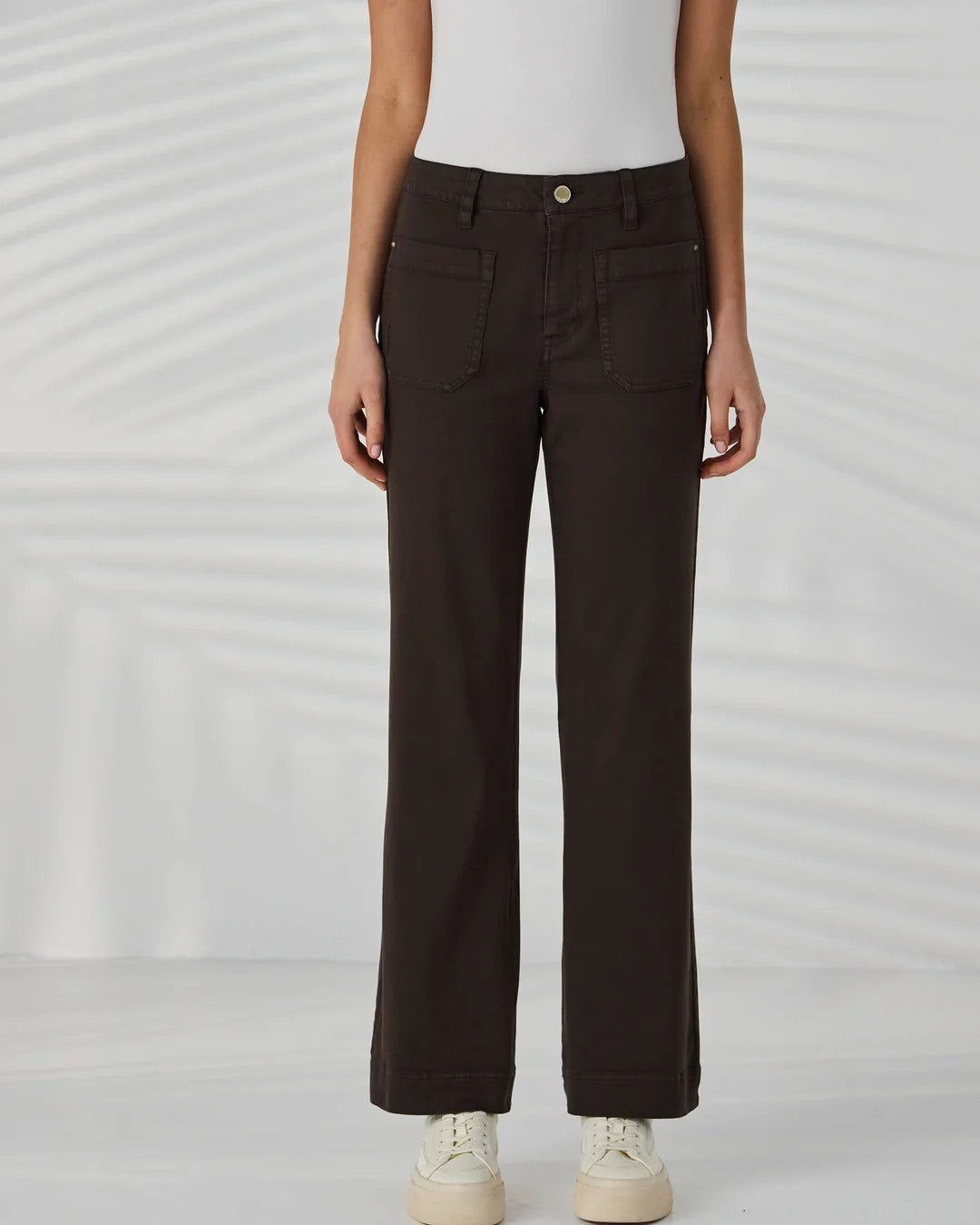  dark brown straight leg jeans, a white top, and white sneakers.