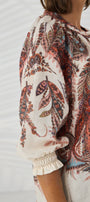 Close up of a person wearing a patterned blouse.