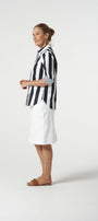 Woman wearing a black and white striped shirt with a white skirt on a white background