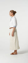 Woman wearing a white shirt and beige pants on a white background