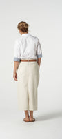 Person wearing a white shirt and beige pants on a white background