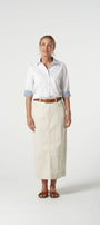 Woman wearing a white shirt and beige skirt on a white background