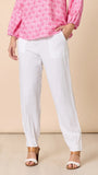 Person wearing a pink floral blouse and white pants on a beige background