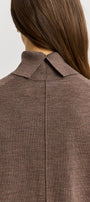 Brown blazer worn by a person on a white background