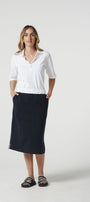 Woman wearing a white shirt and navy skirt on a white background