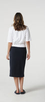 Person wearing a white top and black skirt on a white background