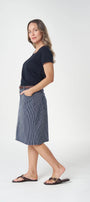Woman wearing a black top and blue skirt on a white background