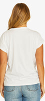 A woman viewed from the back wearing a plain white short-sleeve t-shirt and blue jeans against a light gray studio background.