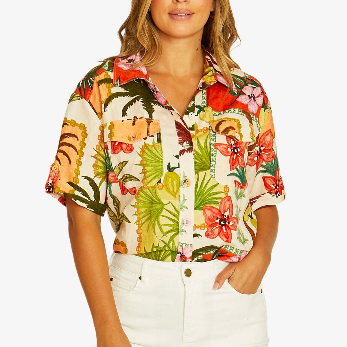Front View  short sleeve button up shirt with a vibrant tropical floral and tiger print, paired with white pants.