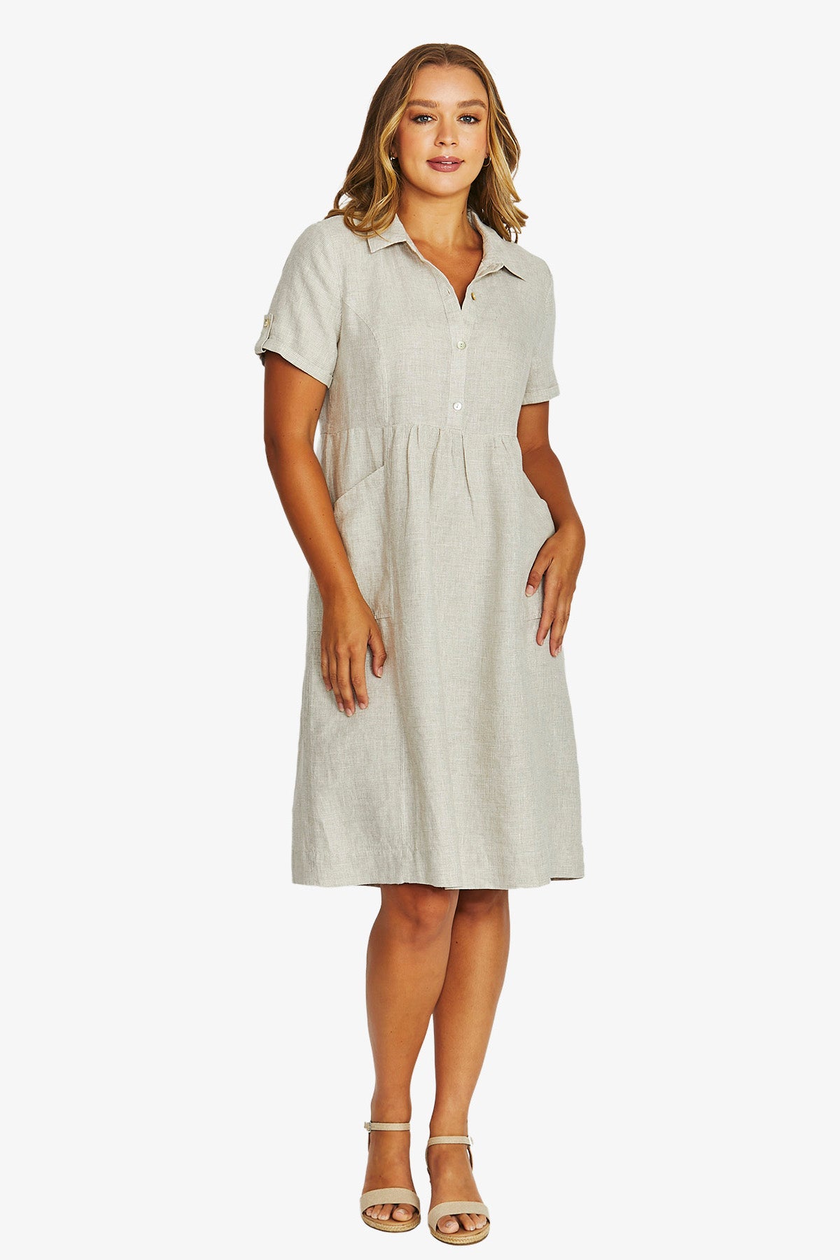 front View  light beige linen shirt dress with short sleeves, a button down collar, and a gathered waist, paired with beige strappy sandals.