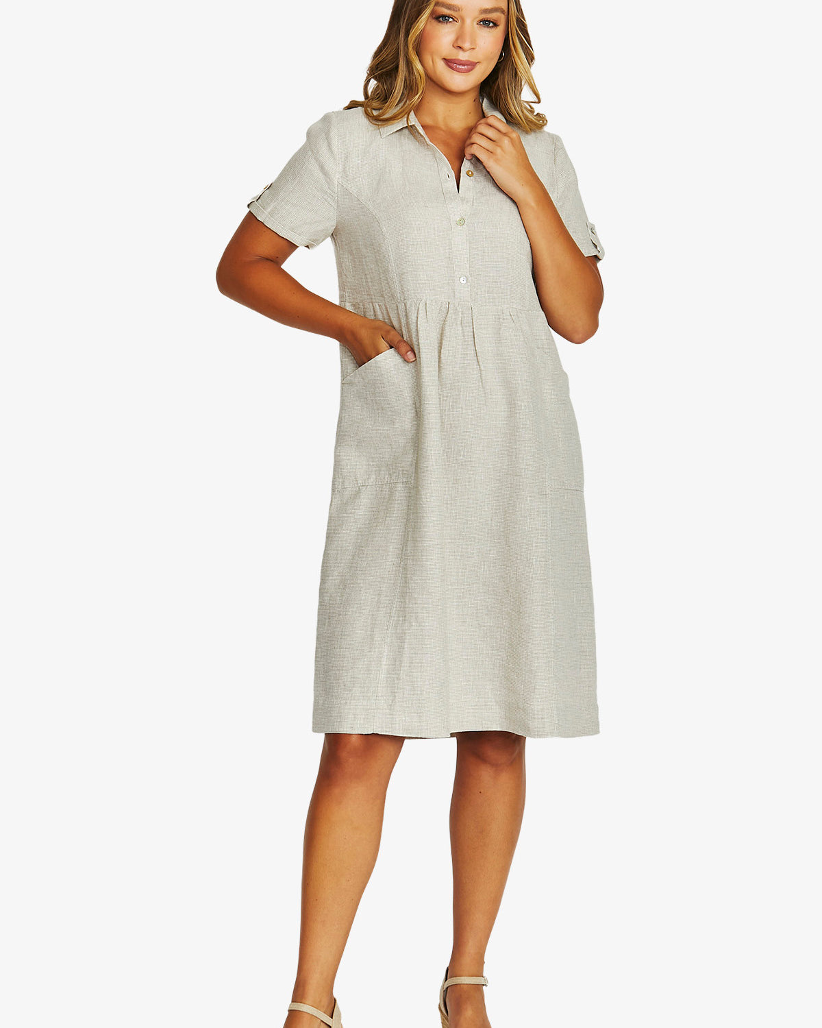 Front View light beige short sleeve linen shirt dress with a button down collar and side pockets, paired with beige wedge sandals.