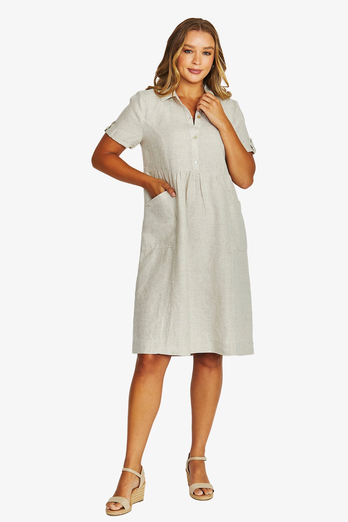 Front View light beige short sleeve linen shirt dress with a button down collar and side pockets, paired with beige wedge sandals.