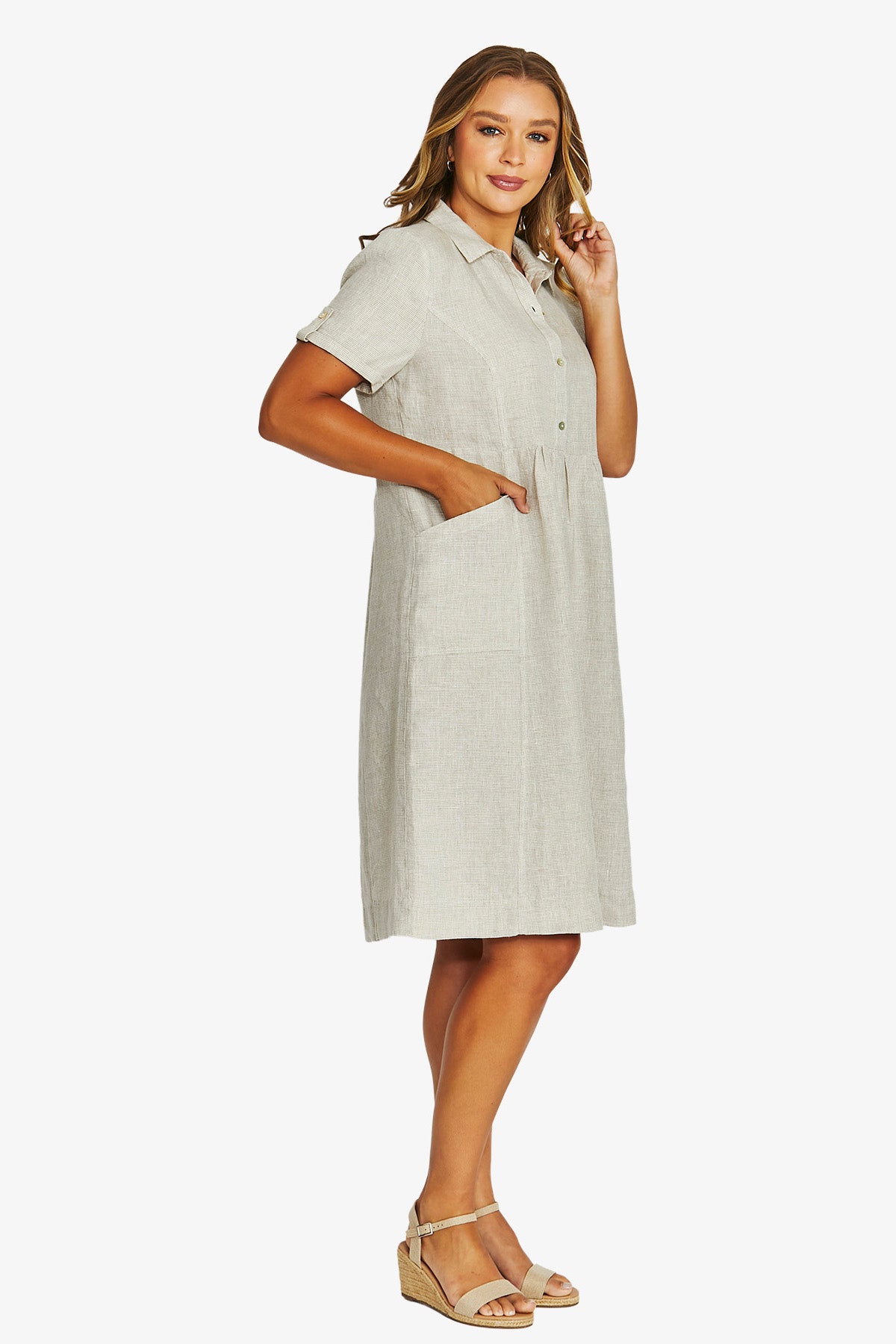 Front View  light beige linen shirt dress with short sleeves, a button down front, and a collar, paired with beige wedge sandals.