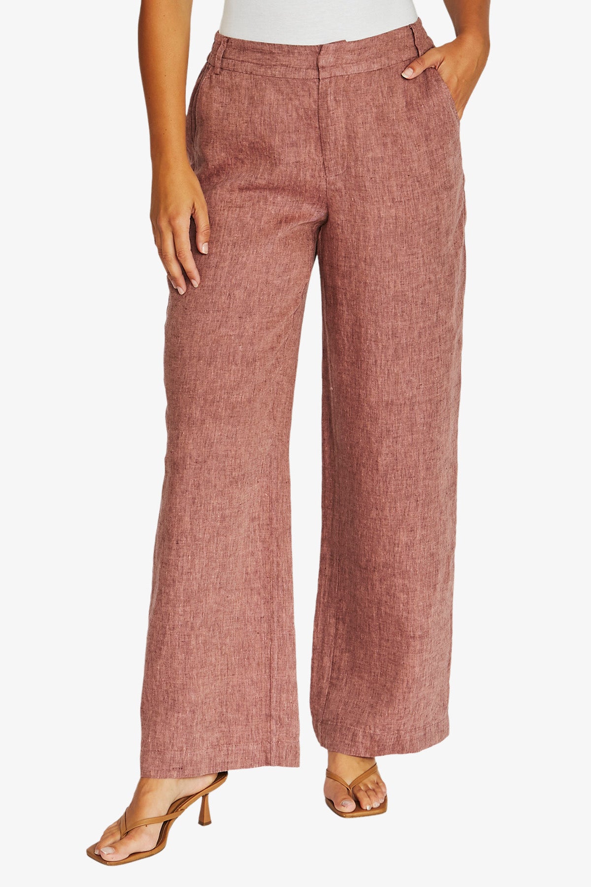 Front view dusty rose wide leg trousers with a textured linen like fabric, paired with a white top and tan heeled sandals, 