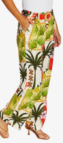 Side View high waisted, wide leg tropical print pants with a white top and tan heeled sandals, shown against a plain light gray studio background.