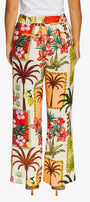 Back view of wide leg trousers featuring a vibrant tropical patchwork print with palm trees, hibiscus flowers, and beach motifs.