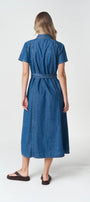 Back View  a blue denim midi dress with short sleeves and a matching waist tie, paired with dark brown sandals.