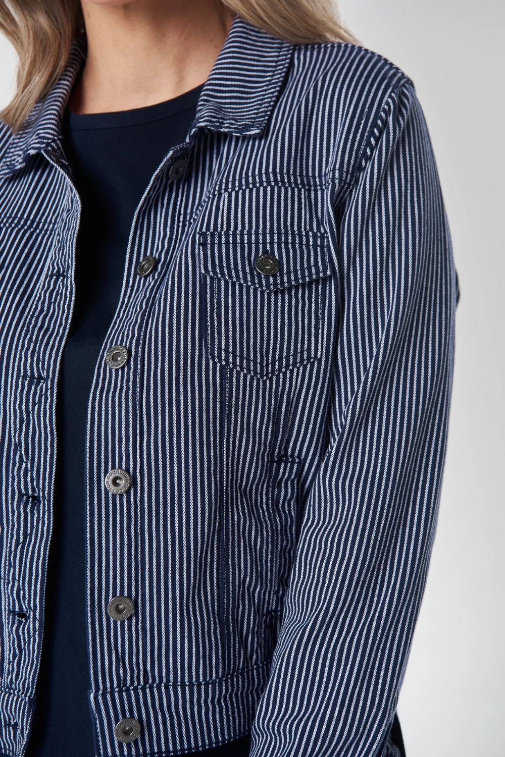 Close up of a person wearing a blue and white striped shirt.