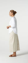 Woman wearing a white shirt and beige pants on a white background