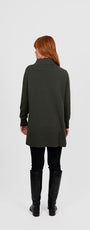 Woman wearing a long dark green coat .