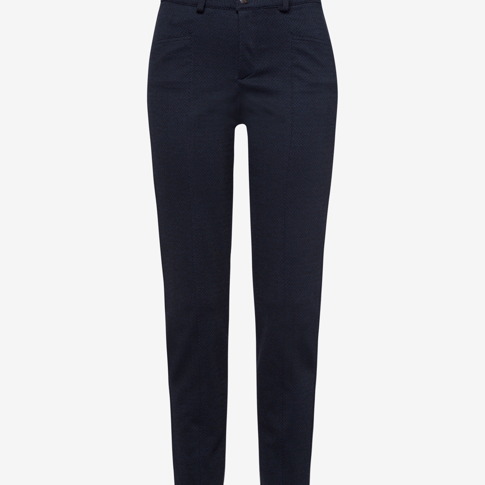 Front view navy coloured skinny pants and a white top, paired with white sneakers.