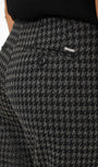 close up Houndstooth patterned pants with a button and brand label .