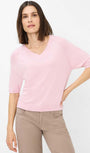 Front view  a pink sweater and beige pants 