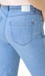 Close-up back view of a person wearing light blue denim jeans, showing the waistband, back pockets, and a small visible Lex brand label.