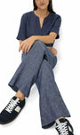 Person wearing a blue outfit with wide-leg pants and sneakers on a white background