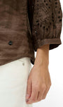 Brown textured shirt with intricate detailing on a white background