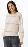 Woman wearing a cream sweater with blue stripes.