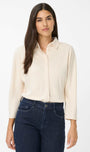 Front view  a cream blouse and dark jeans 