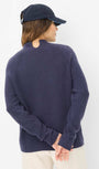 Person wearing a navy sweater and cap Back view