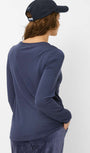 Person wearing a navy long sleeve shirt and cap.