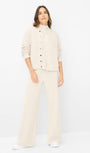 Woman wearing a beige cardigan and pants.