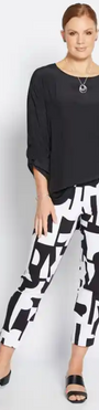 Woman wearing a black top and black and white patterned pants .